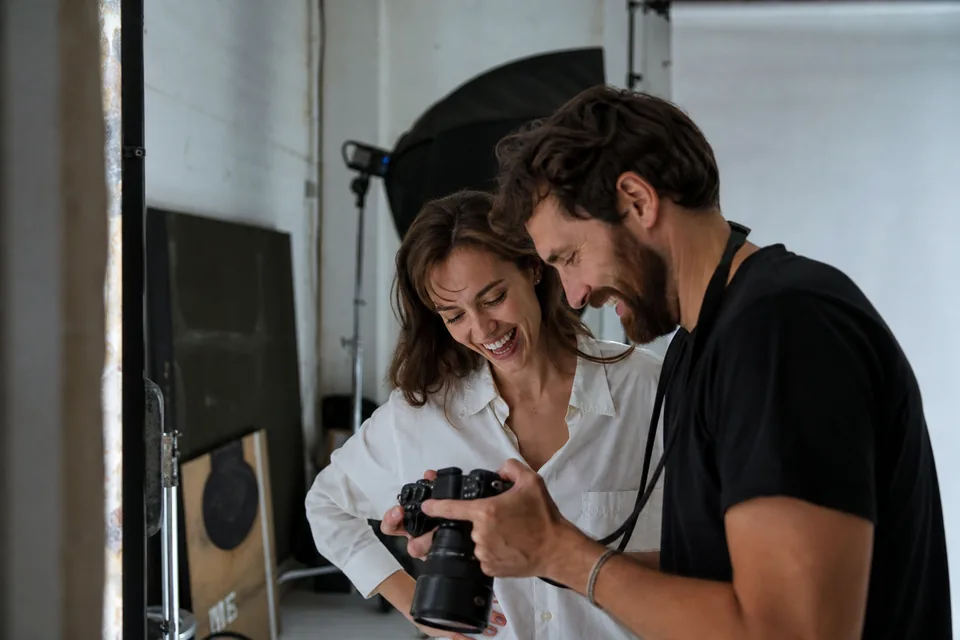 Photographer showing a model the shots on the camera screen